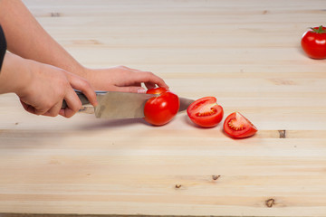 Cutting tomatoes for dishes on the table. Vegetables during the cooking process dishes. Vegetables for healthy eating and dieting