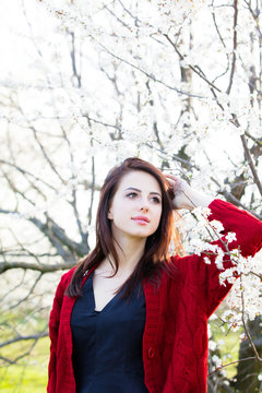 beautiful young woman standing in front of wonderful blooming trees
