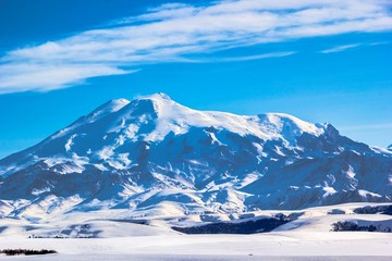Fototapeta na wymiar Высокая гора Эльбрус, красивый вид на снежные вершины, зимний пейзаж, горы Северного Кавказа
