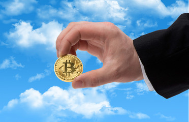 Human Bitcoin in hand against the sky