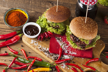 Home made burgers on wooden background.