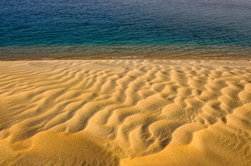 Fototapeta na wymiar Detail view of contrasting sand dunes and ocean water