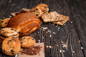 Homemade bakery products on a dark rustic wooden table with space for text