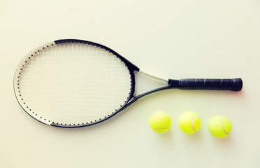 close up of tennis racket with balls