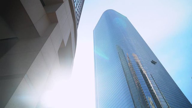 Building Tower Sun / Sunrise in downtown looking up at buildings on a clear blue sky.