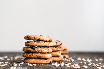Stacks of chocolate chip cookies on dark table with copy space on top