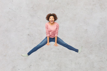 happy african american woman jumping over white