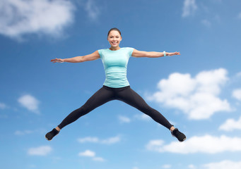 Fototapeta premium happy smiling sporty young woman jumping in air