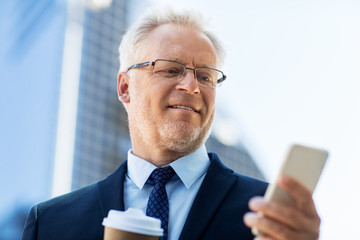 businessman with smartphone and coffee in city