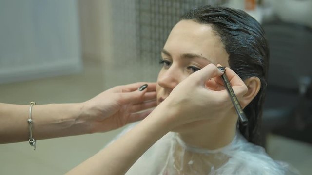 Young woman with hair in the paint, to eyebrow make-up sitting from the master image maker beauty salon ultra HD