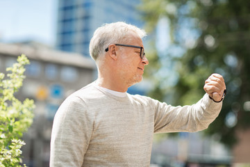 senior man checking time on his wristwatch