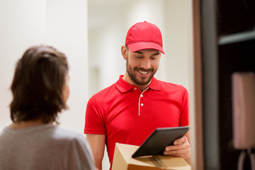 deliveryman with tablet pc and box at customer