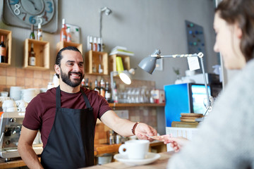 man or waiter serving customer at coffee shop
