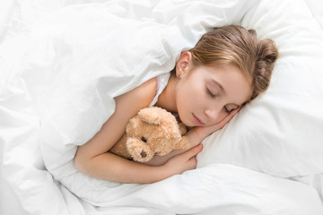 Obraz na płótnie Canvas child hugging her teddy bear in sleep