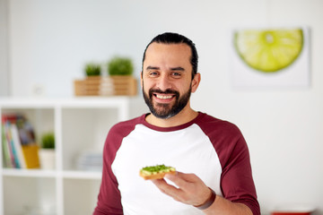 man eating avocado sandwiches at home kitchen