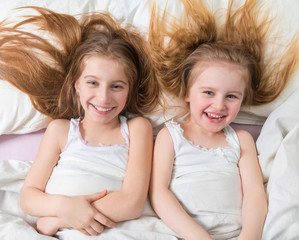 Adorable siblings lying together in bed