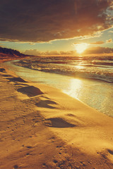 Beatiful sunset with clouds over sea and beach