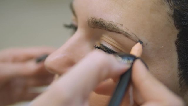 Young woman with hair in the paint, to eyebrow make-up sitting from the master image maker beauty salon ultra HD