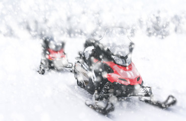 Two red snowmobiles.