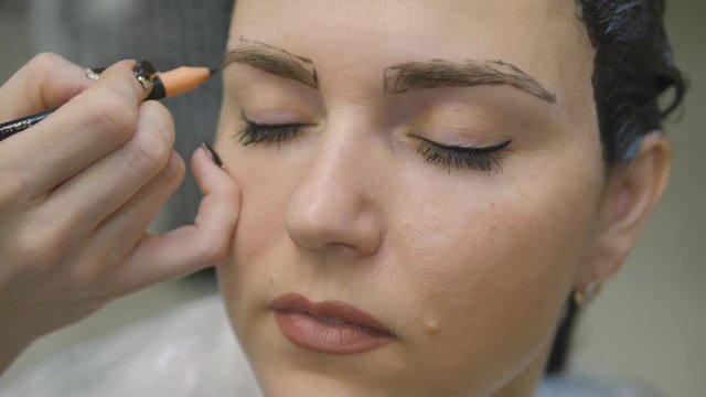 Young woman with hair in the paint, to eyebrow make-up sitting from the master image maker beauty salon ultra HD