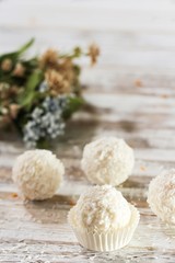 White Chocolate Coconut Truffles with spring flowers in background, selective focus