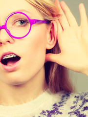 Woman listening carefully with hand close to ear