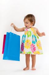 Little girl is surprised with colorful paper bags isolated on white background.