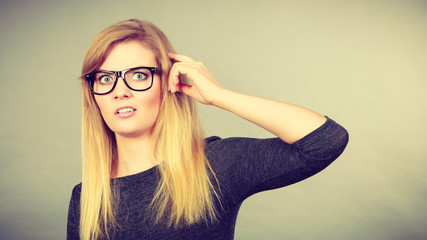 Nerdy woman in eyeglasses being confused