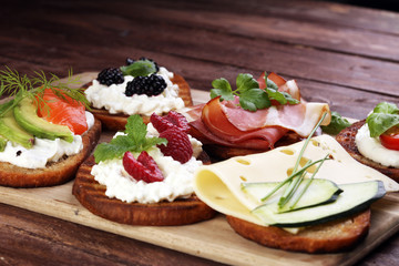 Bread Brushetta or authentic traditional spanish tapas set for lunch table. Sharing antipasti on party or summer picnic time over wooden rustic background.