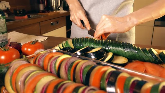 Woman cutting red tomato. Cooking homemade ratatouille. Healthy eating concept. 4K video