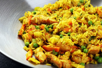 Udon stir-fry rice with shrimp and vegetables in wok pan on black burned stone background