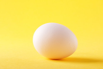 white egg on a yellow background