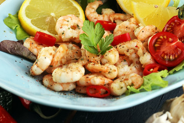 fresh shrimps served on a plate with garlic onion, lemon and chili