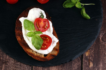 Bread with cream cheese and tomato for lunch table. Sharing antipasti on party or summer picnic...