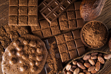 Dark homemade chocolate bars and cocoa pod on wooden
