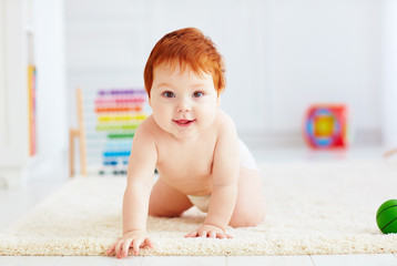 portrait of cute happy infant baby crawling on carpet at home