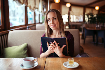 Woman in a restaurant holding menu in hands