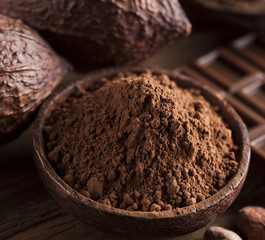 Chocolate bar, candy sweet, cacao beans and powder on wooden background