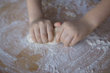 dziecięce dłonie ugniatające ciasto