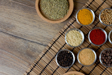 Fototapeta na wymiar Various fresh spices in bowls, wooden background, 