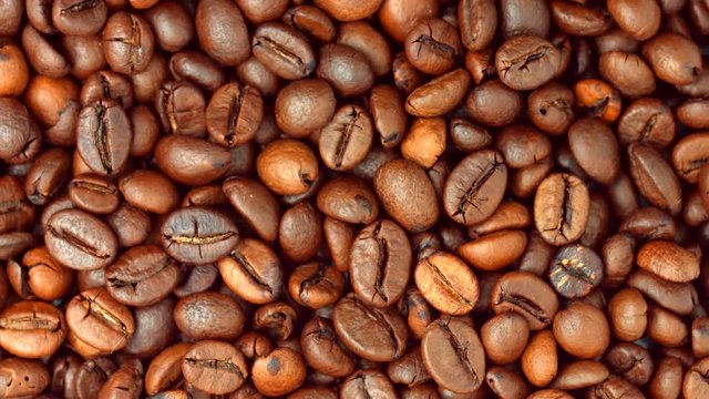 Coffee beans rotating background. Roasted coffee closeup