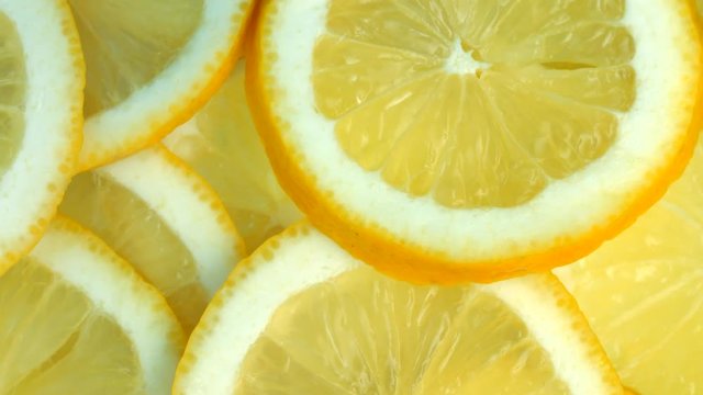 Lemon slices rotation background. Close-up of a delicious ripe lemon rotate