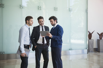 Businessman presenting idea to associates using digital tablet