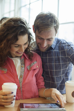 Couple using digital tablet in coffee shop