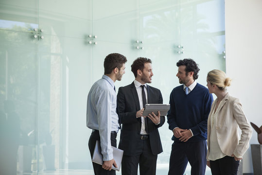Business people discussing with each other in the office corridor