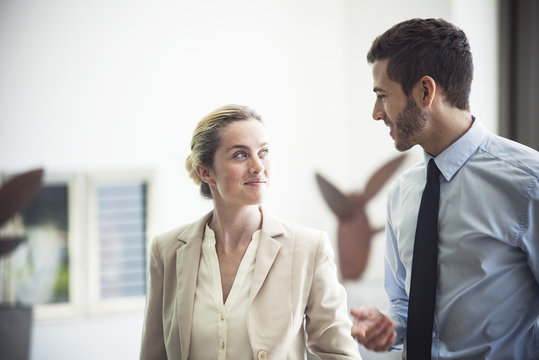Business colleagues talking together in office