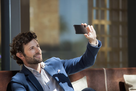 Man using smartphone to take a selfie