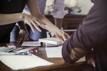 Designer showing color swatches to client, cropped