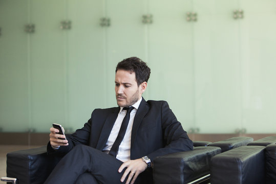 Executive looking at cell phone with concerned look
