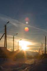 Power lines at sunset background in the winter city with colourful clouds.